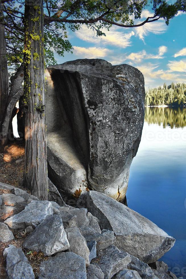 roca de granito en la orilla del lago con bosque foto