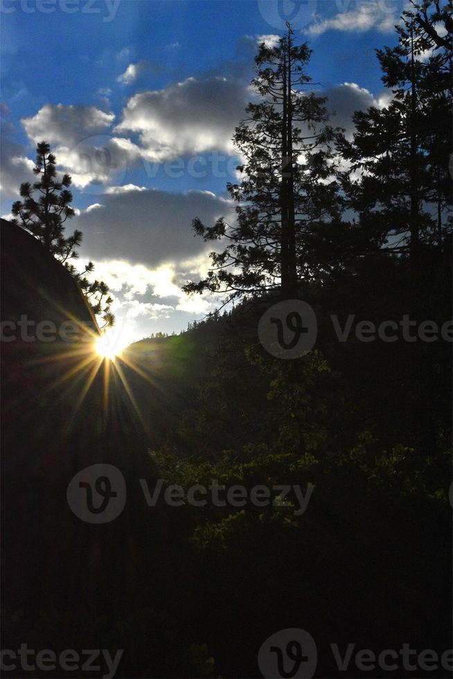 Mountain Sunrise with Clouds Blue Sky and Tree Silhouettes photo