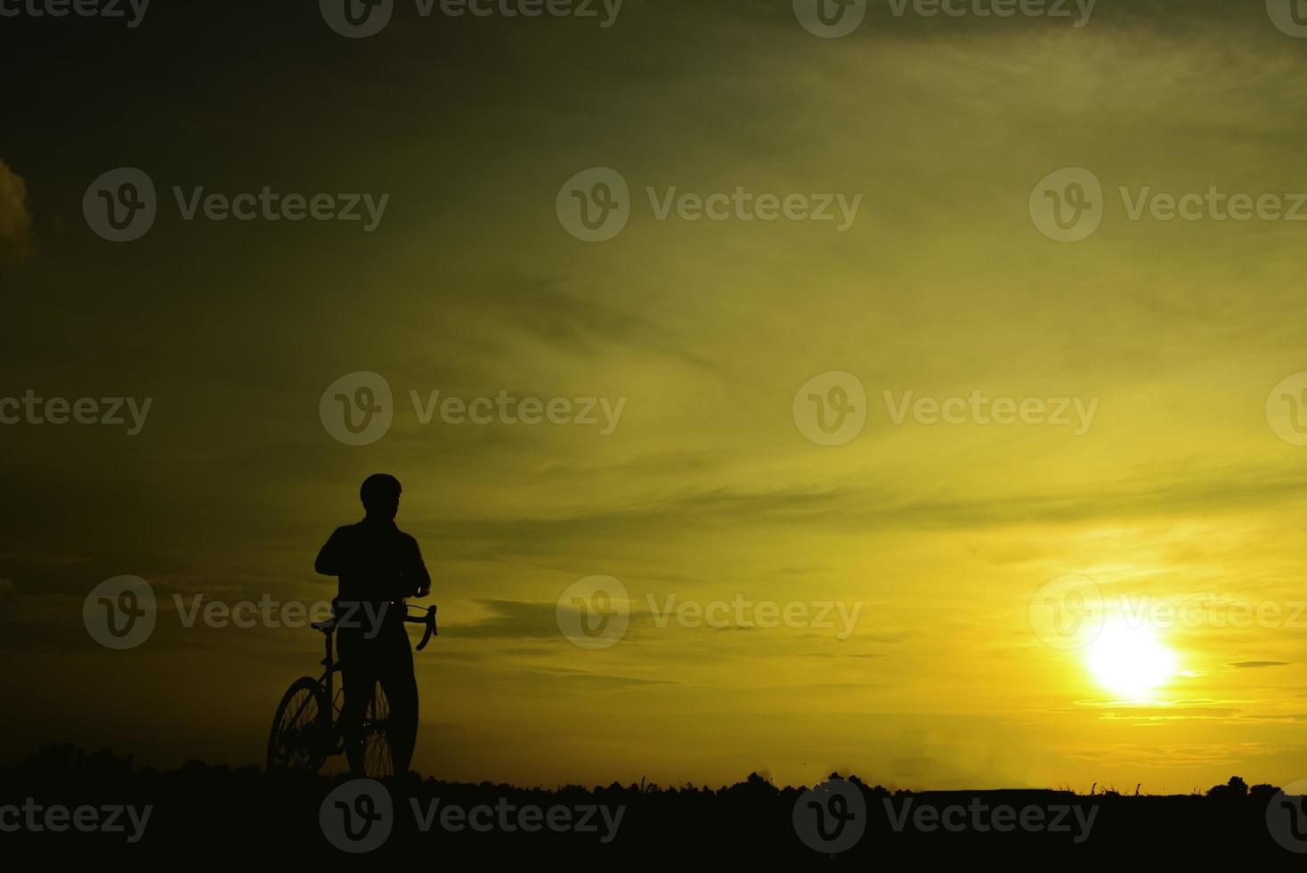 Silhouette of handsome man riding bicycle on sunset,sport man concept photo