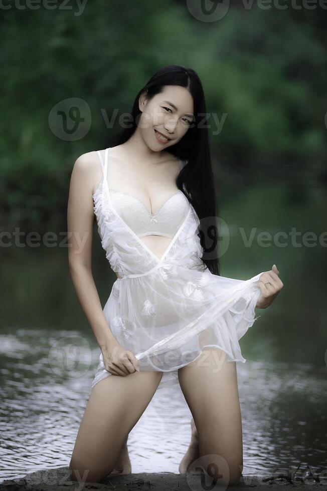 Portrait of sexy asian woman at the waterfall,Feeling fresh at the river,Thai female relax at country photo