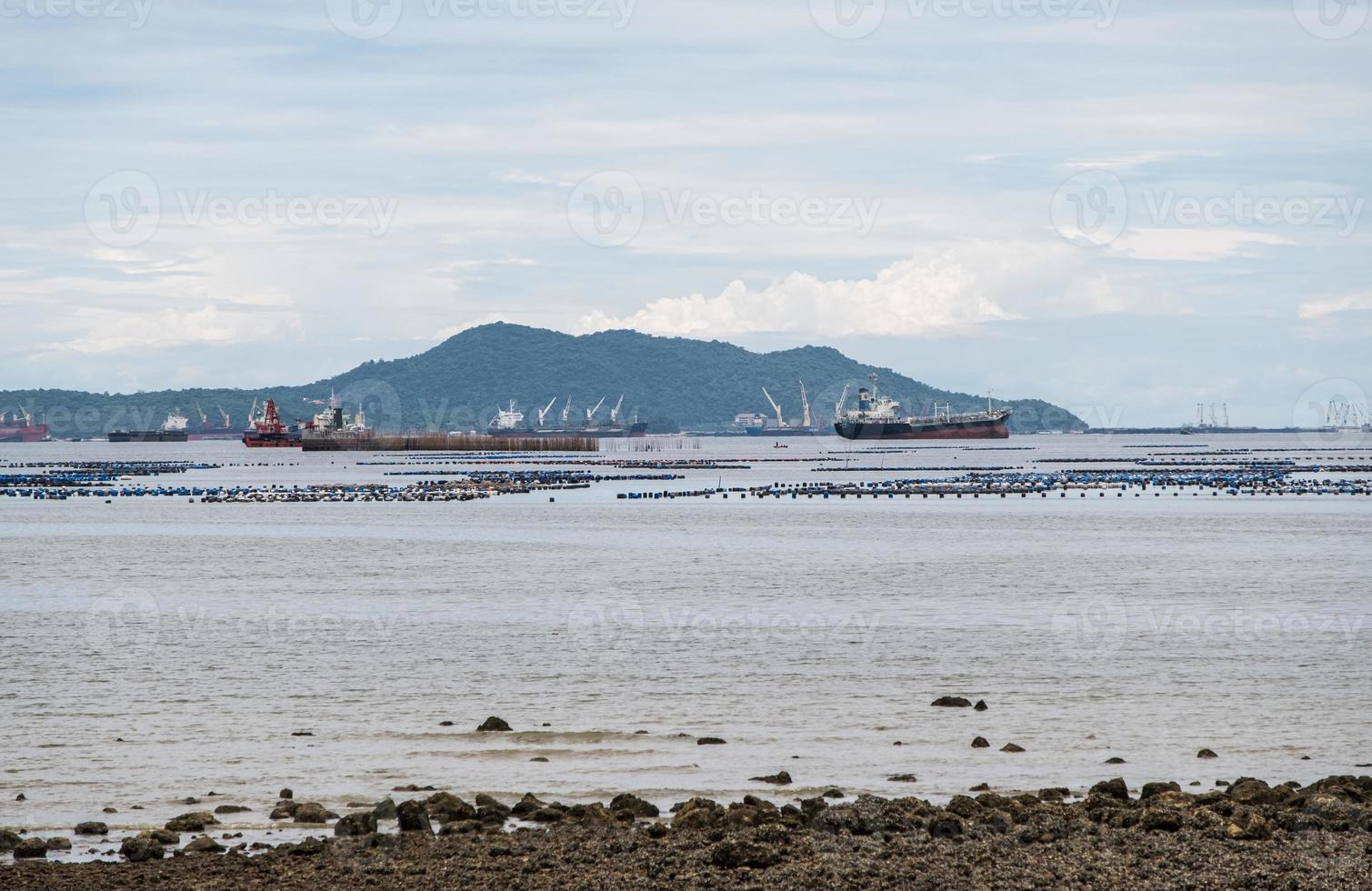 Many of the cargo ships are waiting near the harbor. photo