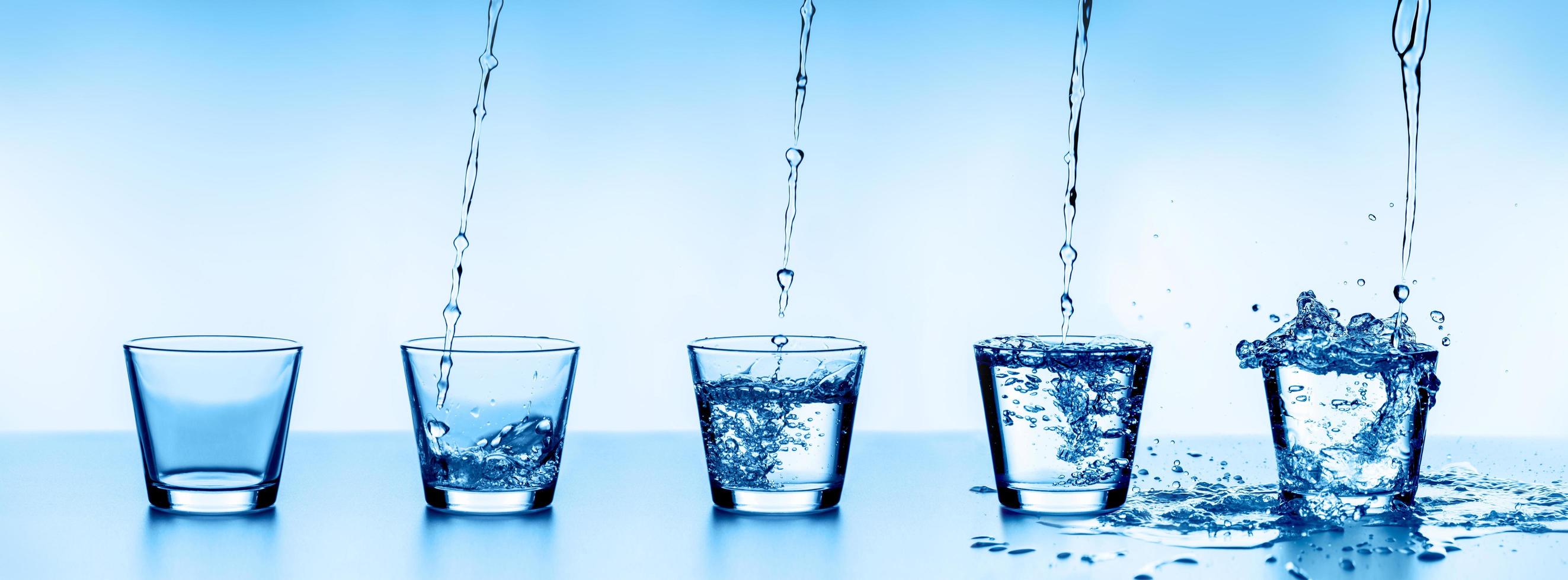 cinco vasos de agua de agua, dispuestos en orden ascendente. foto