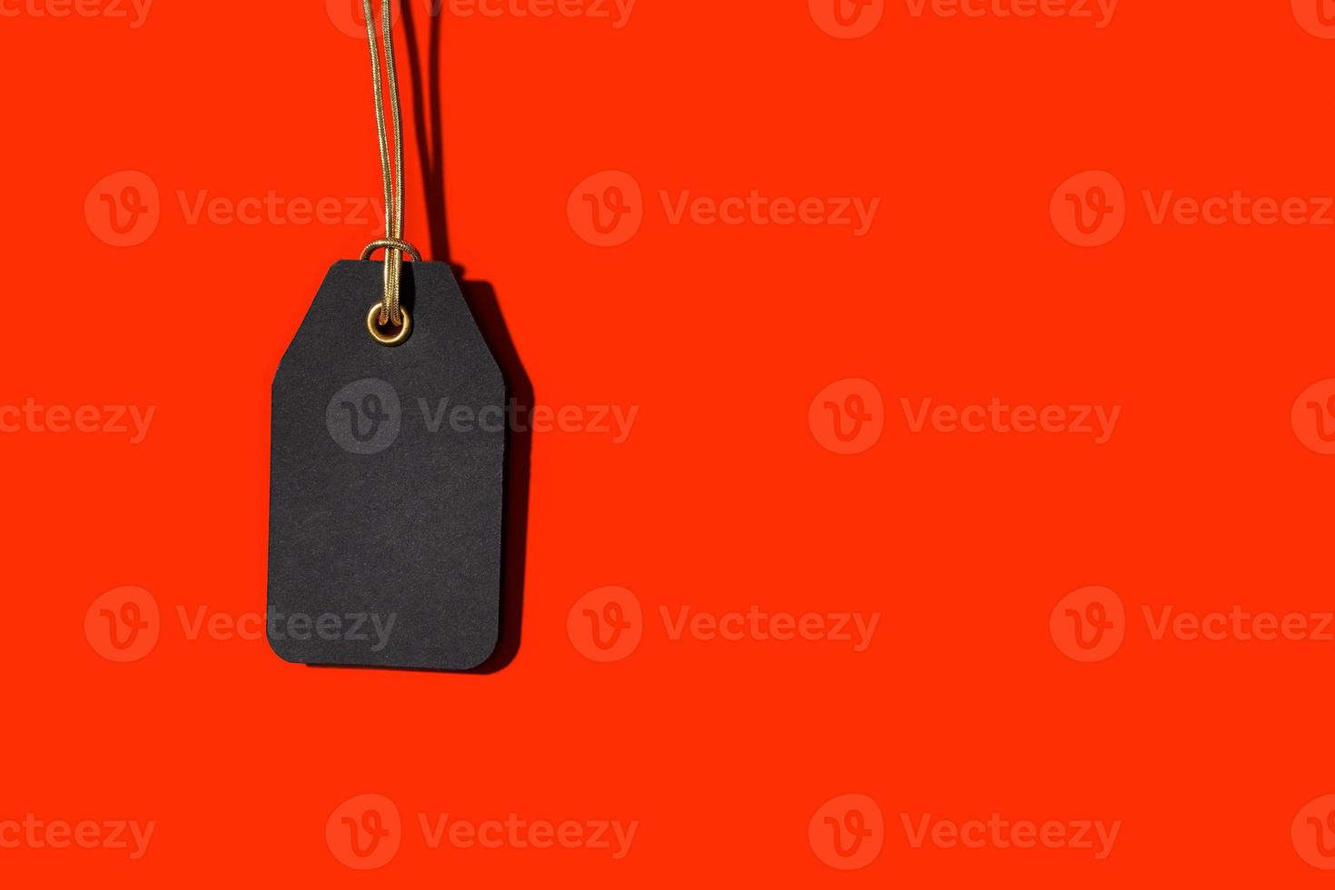 Blank black tag isolated on red background with copy space. Template Mock up photo