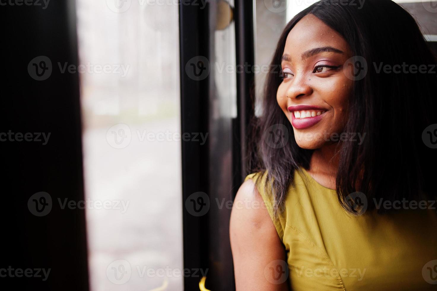 joven mujer afroamericana con estilo montando en un autobús. foto