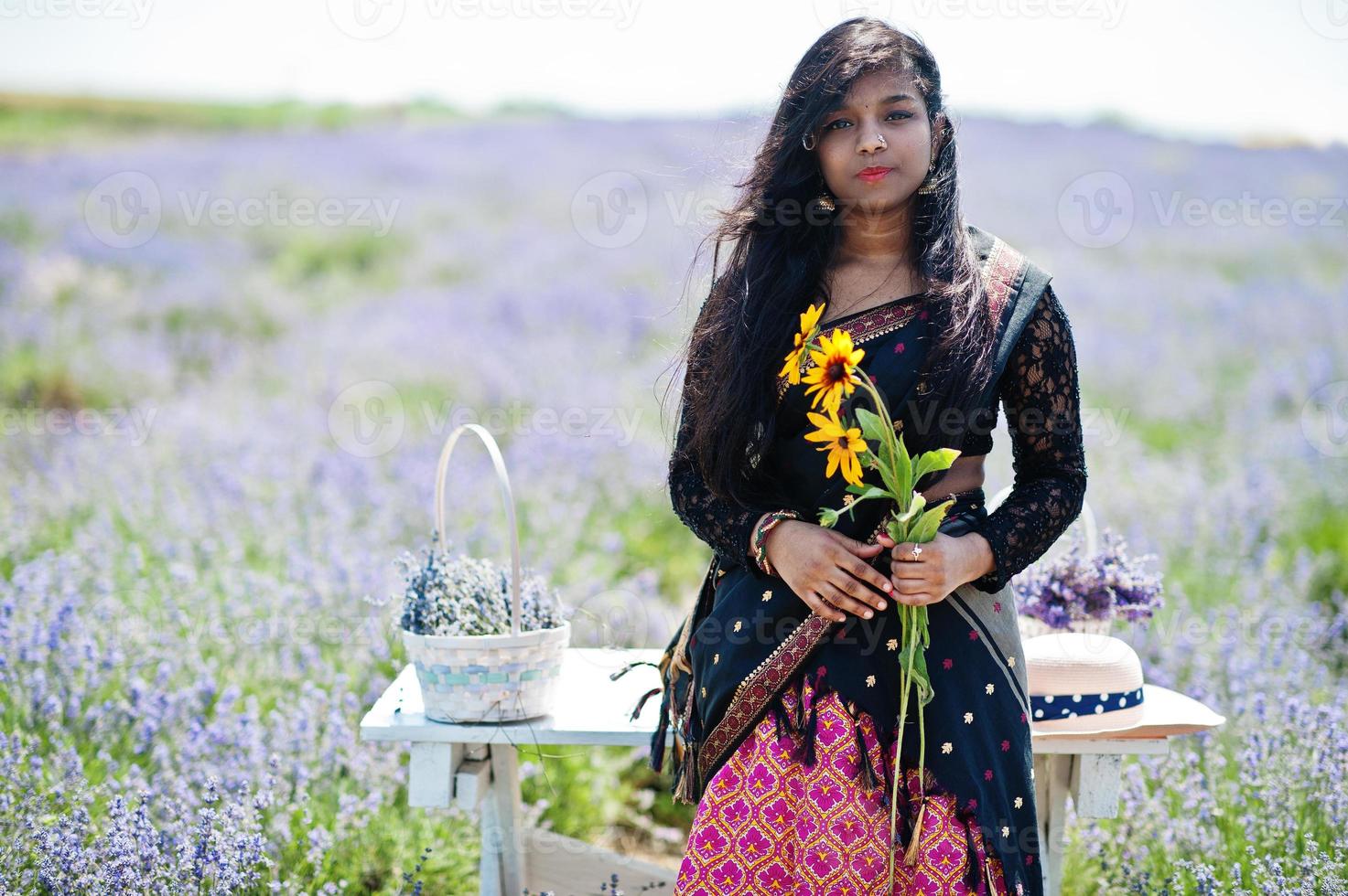 Beautiful indian girl wear saree india traditional dress in purple lavender field. photo