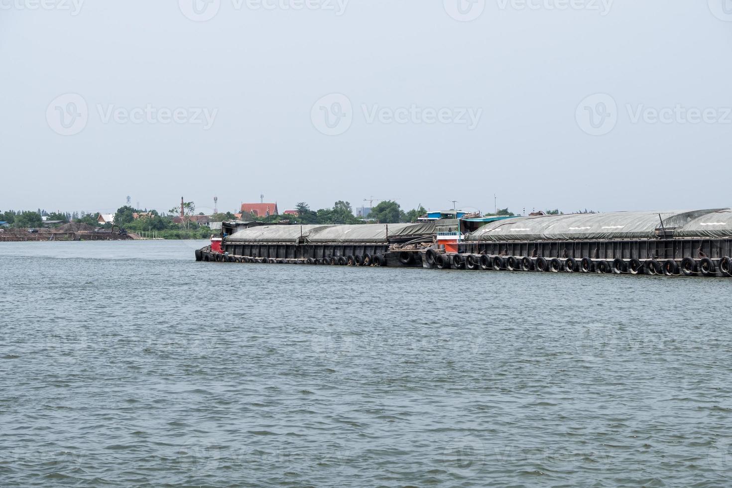 The large cargo boat is loading the sand  in the large river. photo