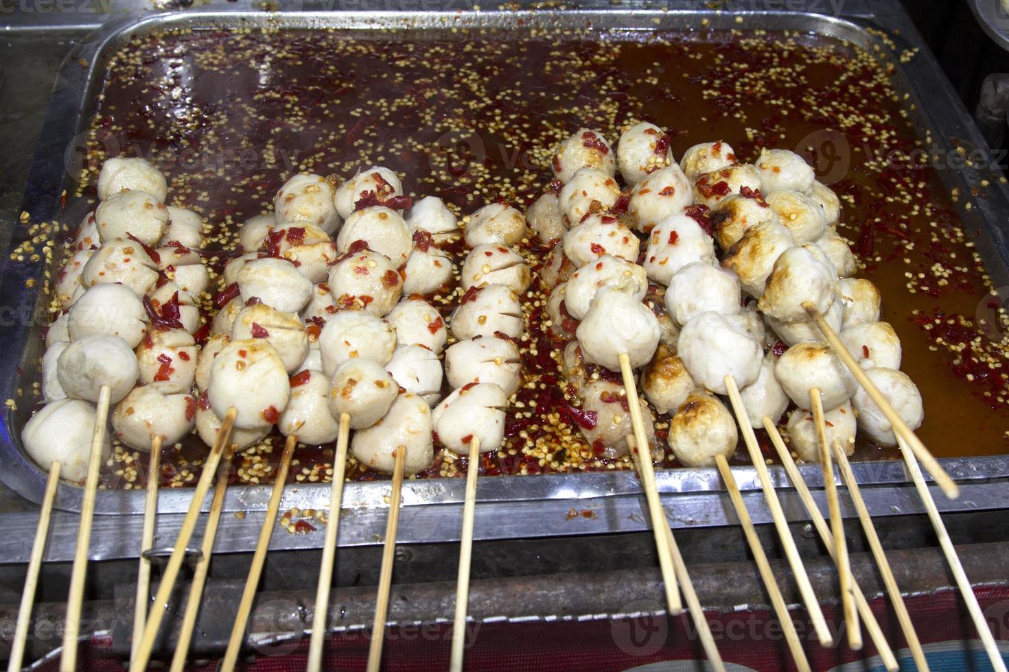 Meatballs grilled in chili sauce Snacks and Thai food that chefs are grilling hot for customers to order, fresh and delicious, selling at many roadside seen in Thailand at night and every festival photo