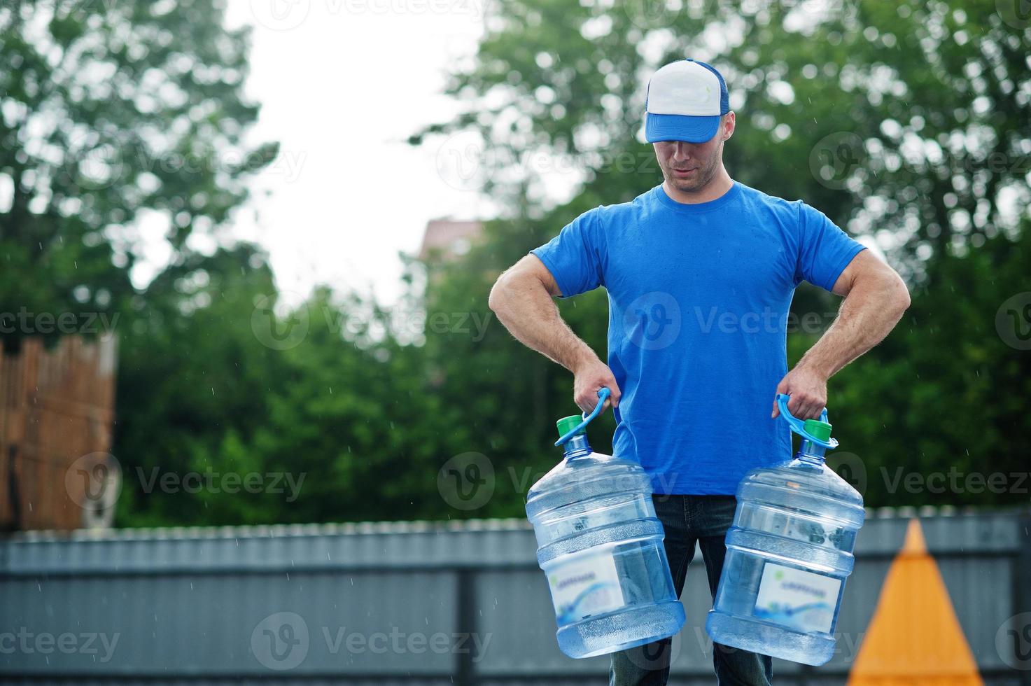 repartidor con botellas de agua en las manos. foto