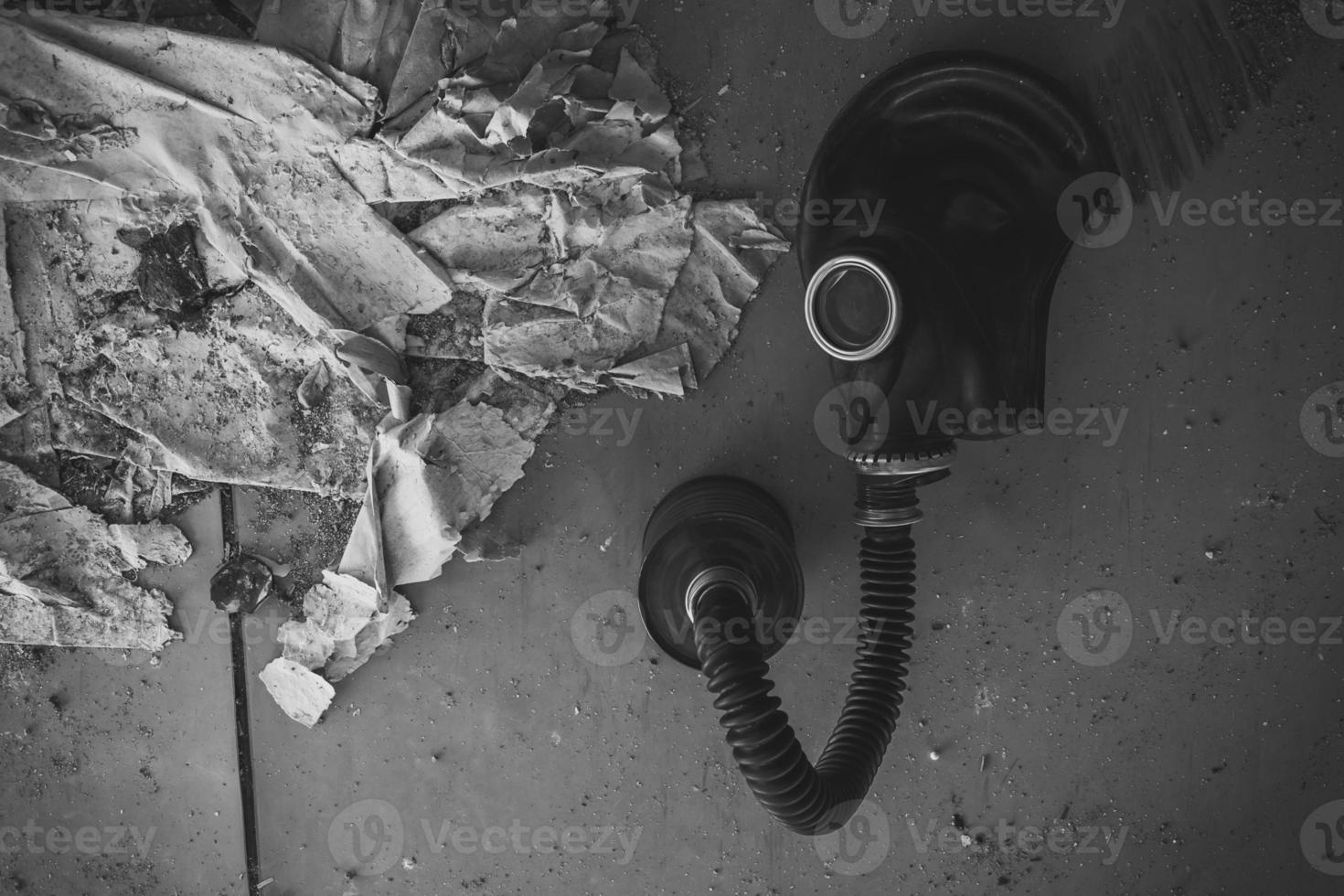 Old wartime gas mask and canister on a floor photo