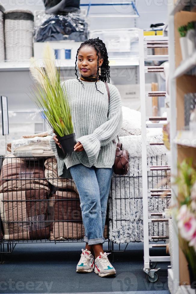 African woman choosing pot decoration for her apartment in a modern home furnishings store. photo