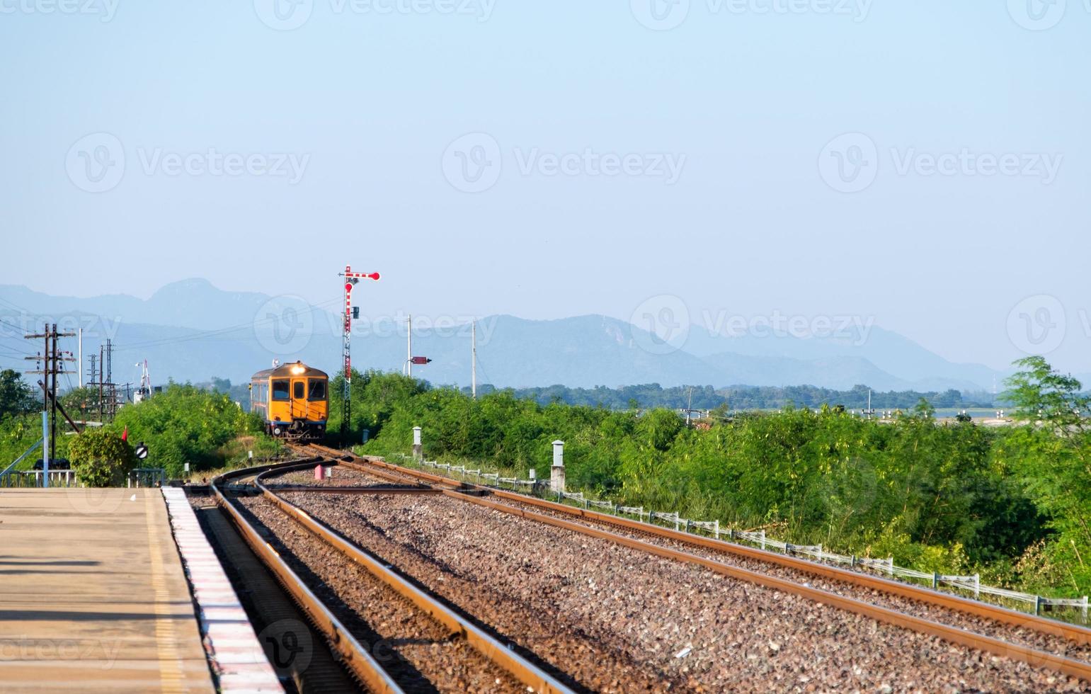 The old diesel multiple unit of the local train is arriving at the platform of the rural station. photo