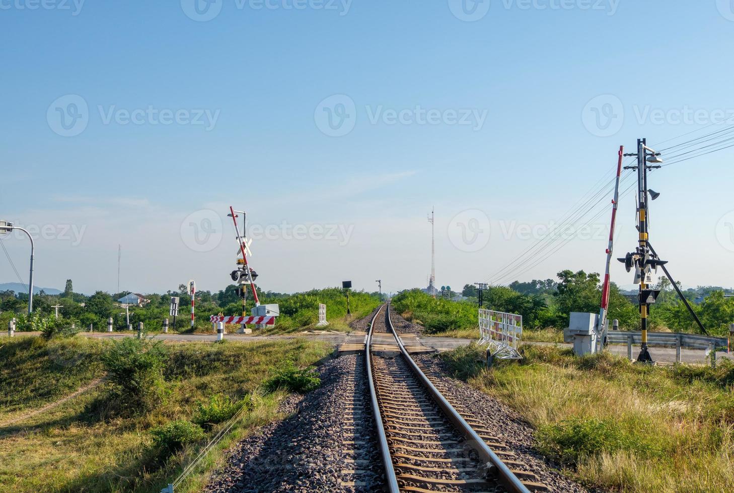 el cruce ferroviario automático en la carretera rural antes de la estación de tren local. foto