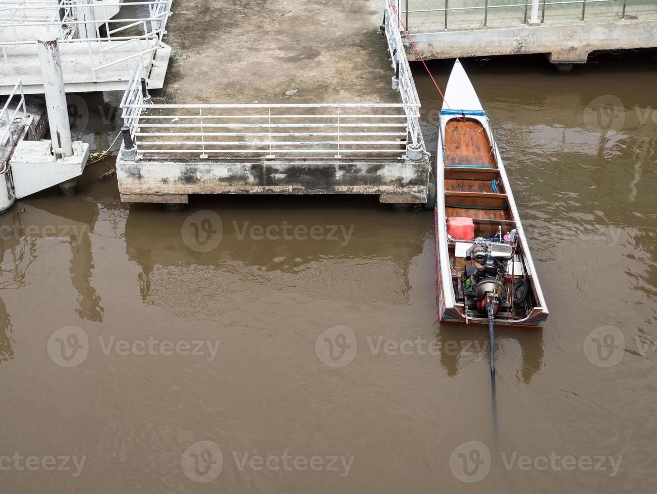 Old long tail boat near the concrete pontoon. photo