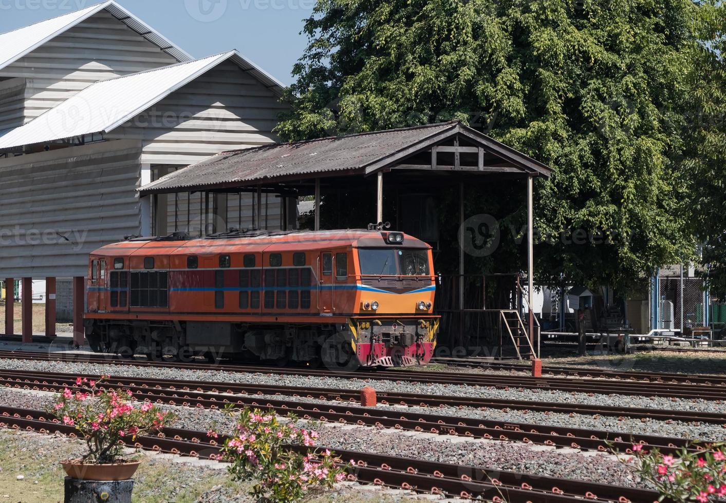 Old diesel electric locomotive is parking near the depot. photo