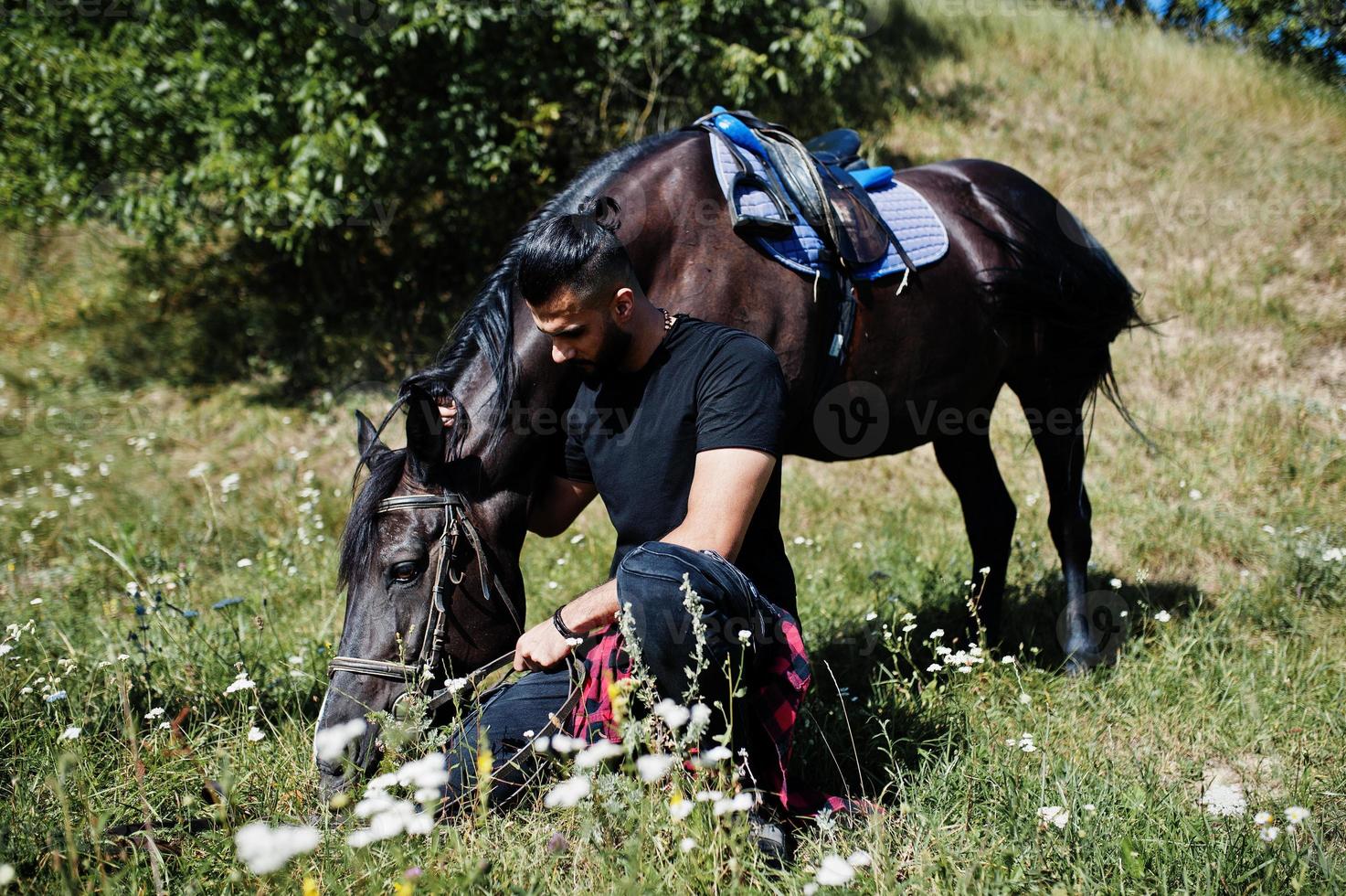 Arab tall beard man wear in black with arabian horse. photo