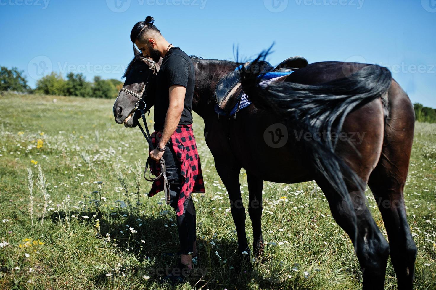 Arab tall beard man wear in black with arabian horse. photo