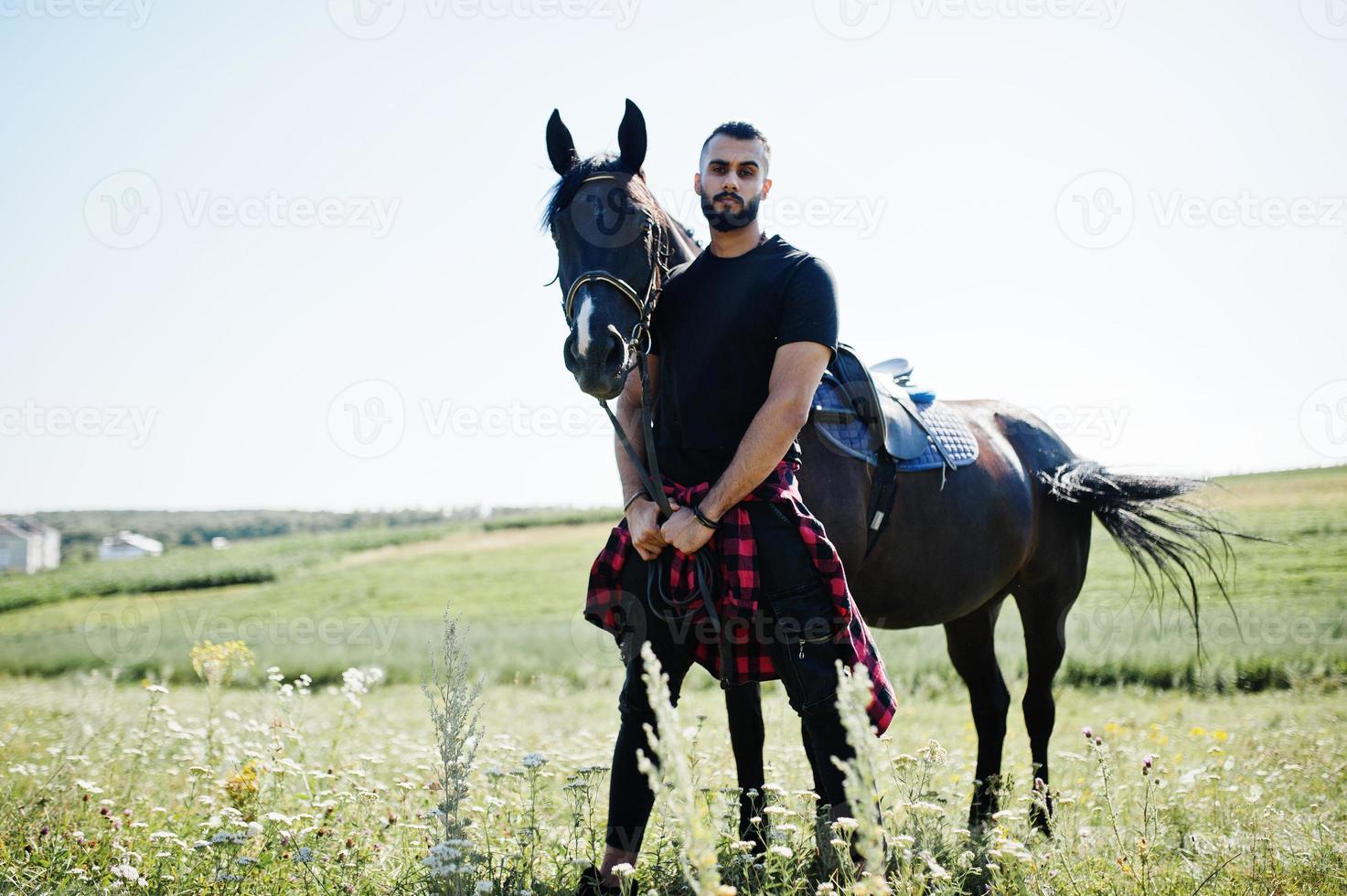 Arab tall beard man wear in black with arabian horse. photo