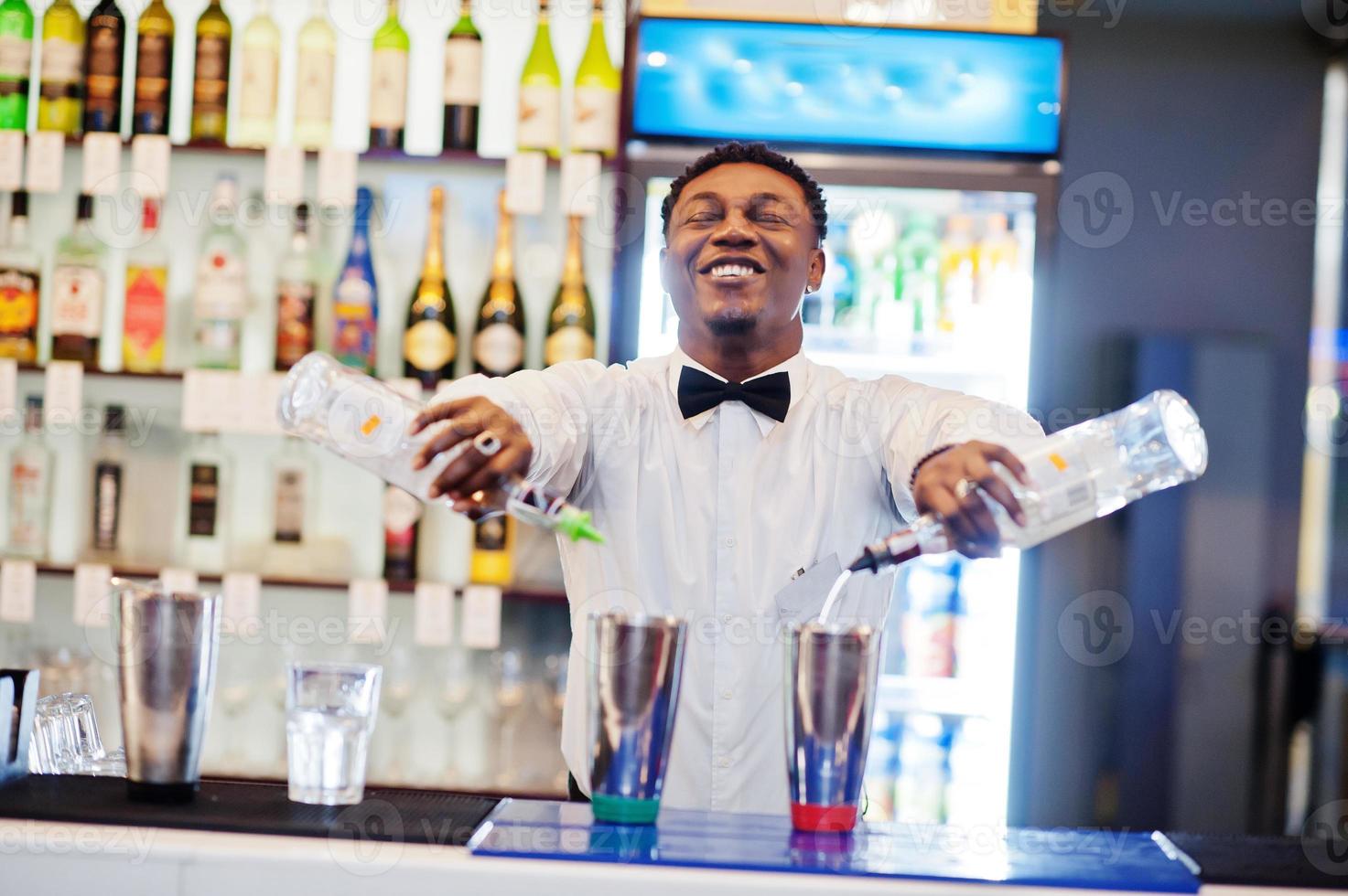 camarero afroamericano trabajando detrás del bar de cócteles. preparación de bebidas alcohólicas. foto