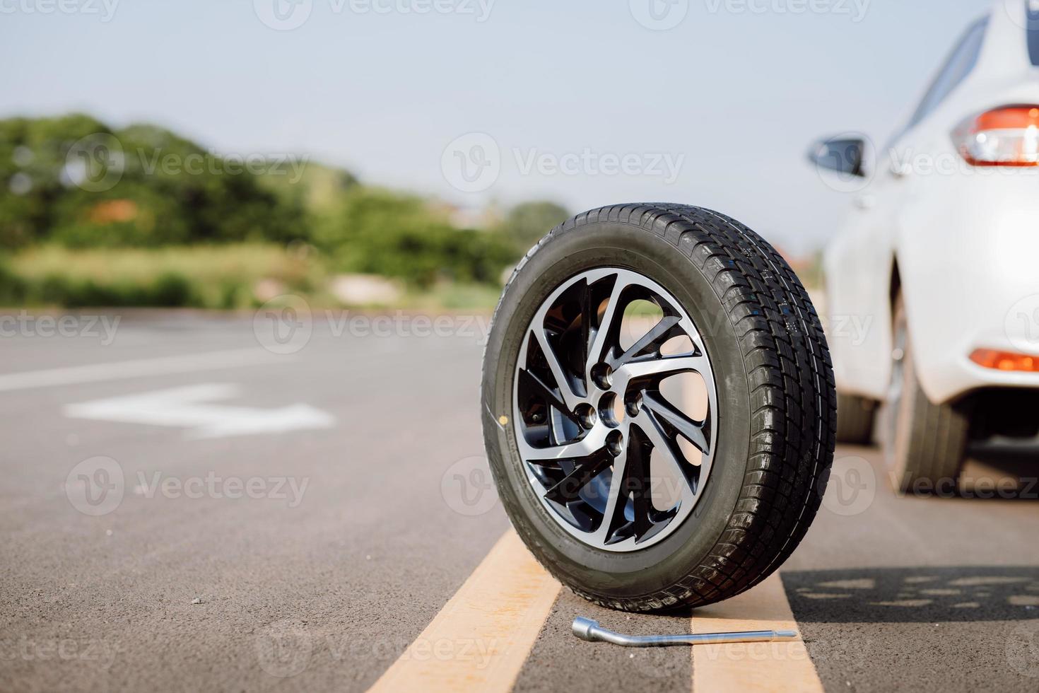 Spare wheel on the road. Concept for changing a flat tire on road. photo