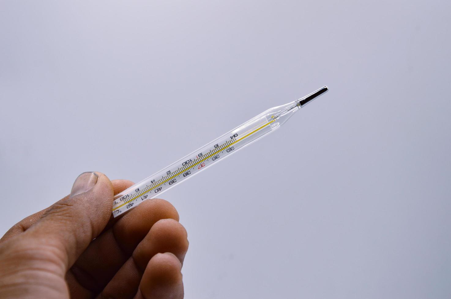 old man's hand holding a thermometer, white background, concept, sick, unwell, fever, smallpox monkey photo