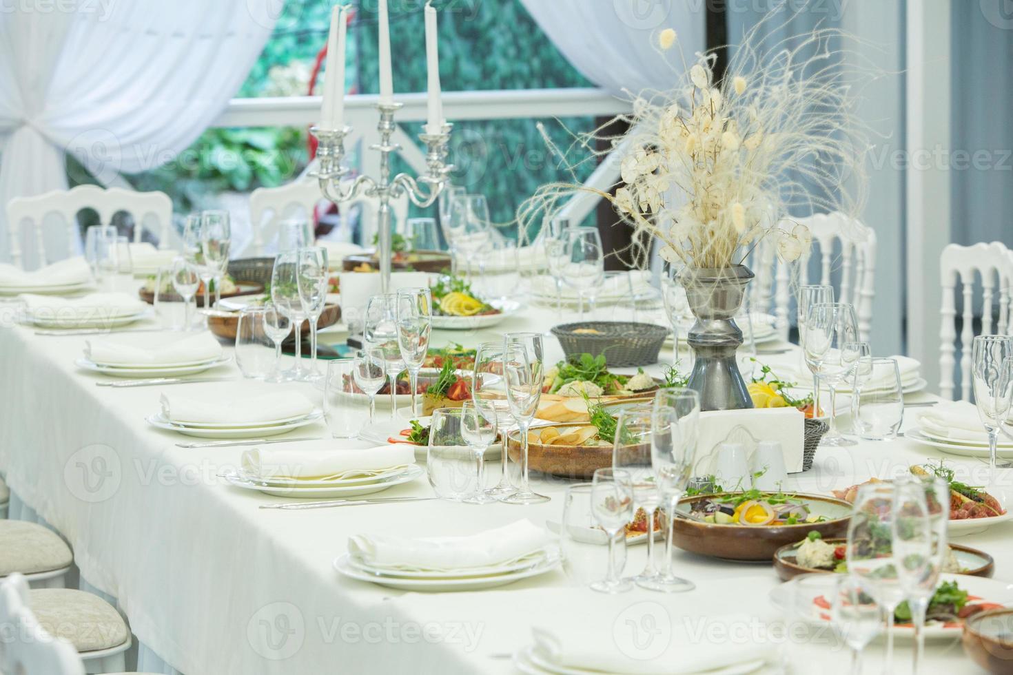 Empty banquet hall ready to receive guests on the summer terrace. white festive table photo