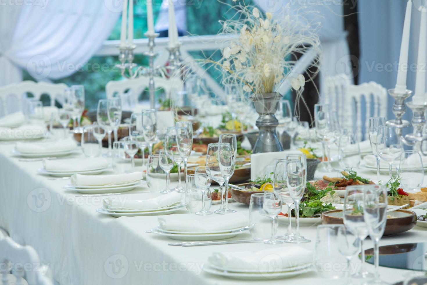 Empty banquet hall ready to receive guests on the summer terrace. white festive table photo