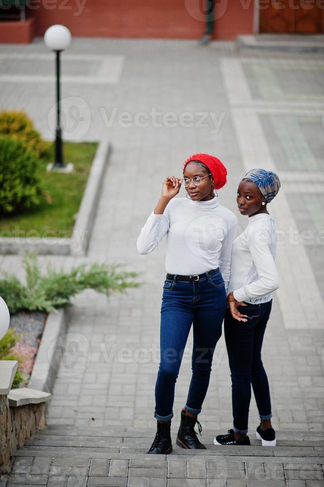 Two young modern fashionable, attractive, tall and slim african muslim womans in hijab or turban head scarf posed together. photo