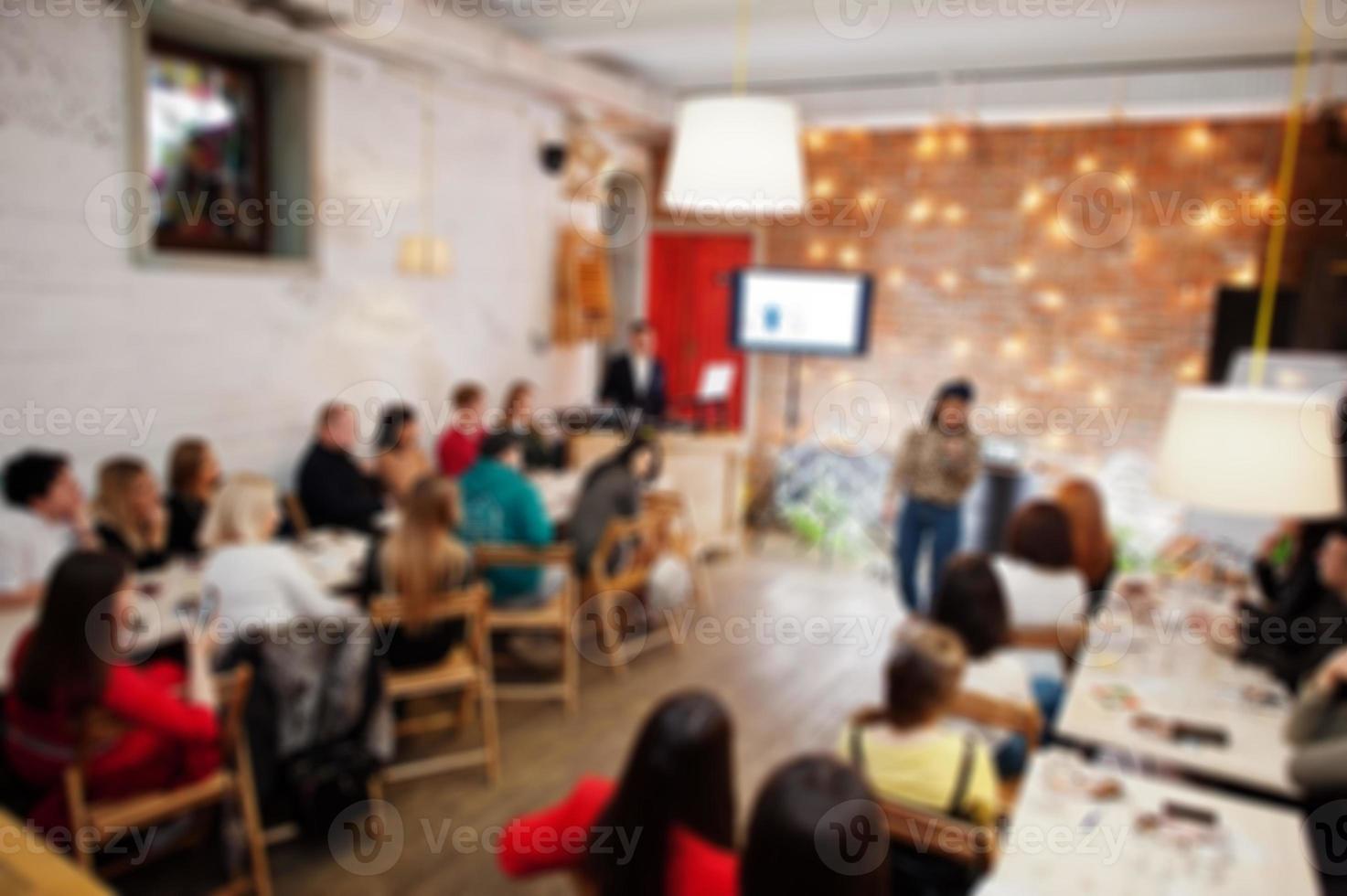 Master class and study concept. Abstract blurred photo of conference or seminar room with speaker on the stage.