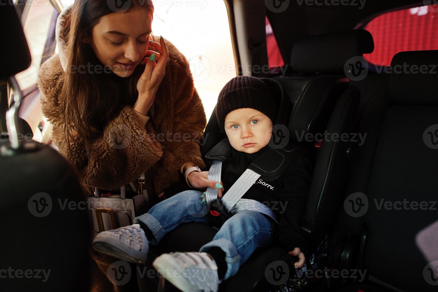 Young mother and child in car. Baby seat on chair. Safety driving concept. photo