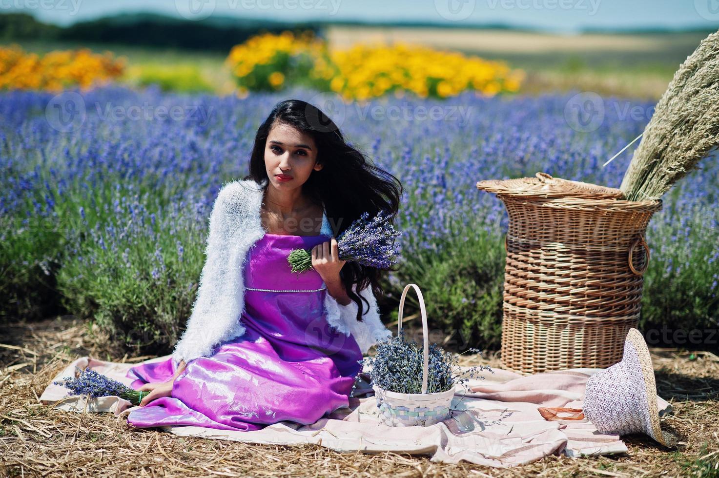 Beautiful indian girl wear saree india traditional dress in purple lavender field with basket. photo