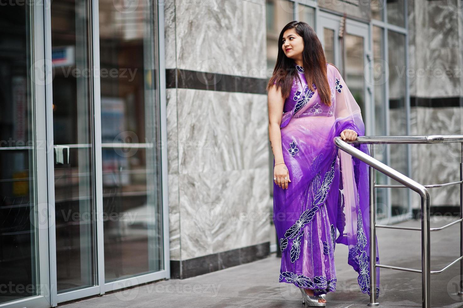 Indian hindu girl at traditional violet saree posed at street. photo