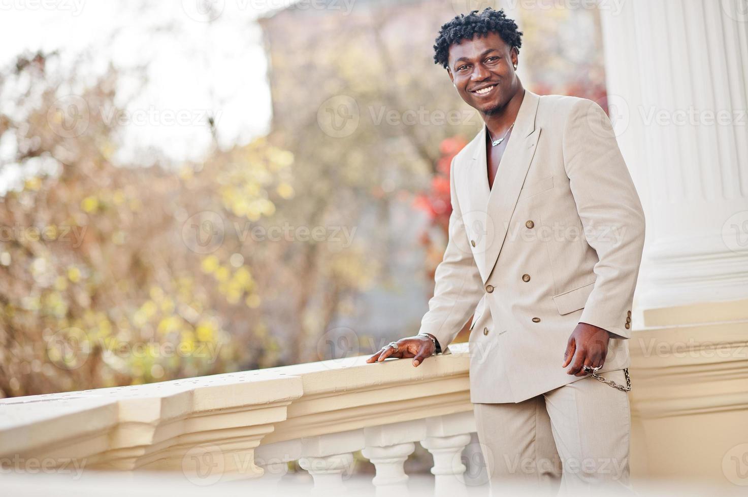 Stylish afro man in beige old school suit. Fashionable young African male in casual jacket on bare torso. photo