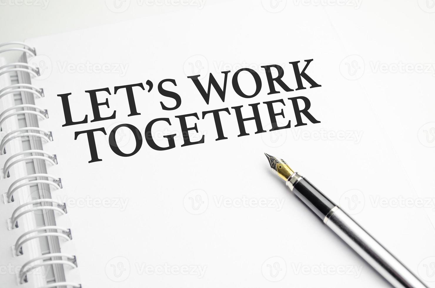 let's work together words on white notepad and pen photo