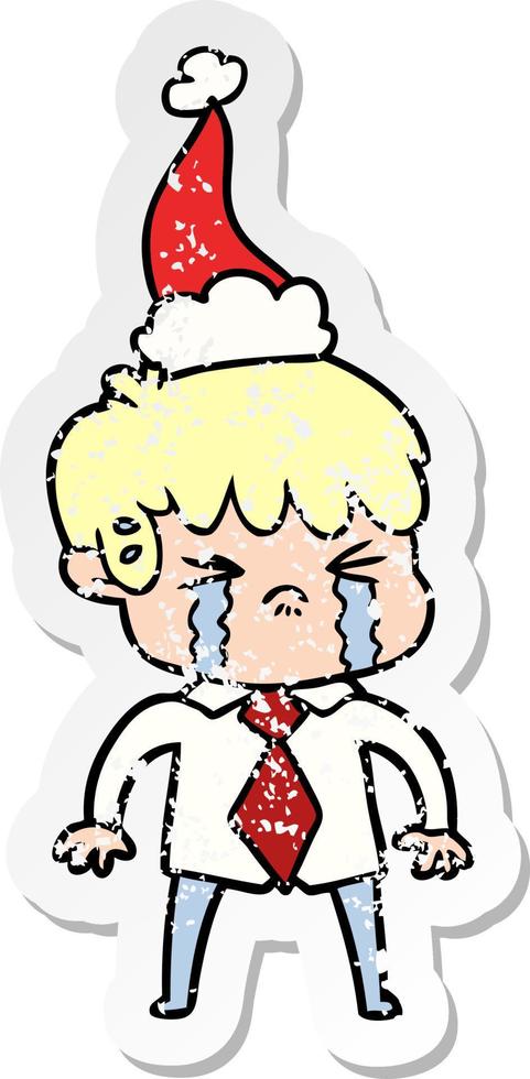 distressed sticker cartoon of a boy crying wearing santa hat vector