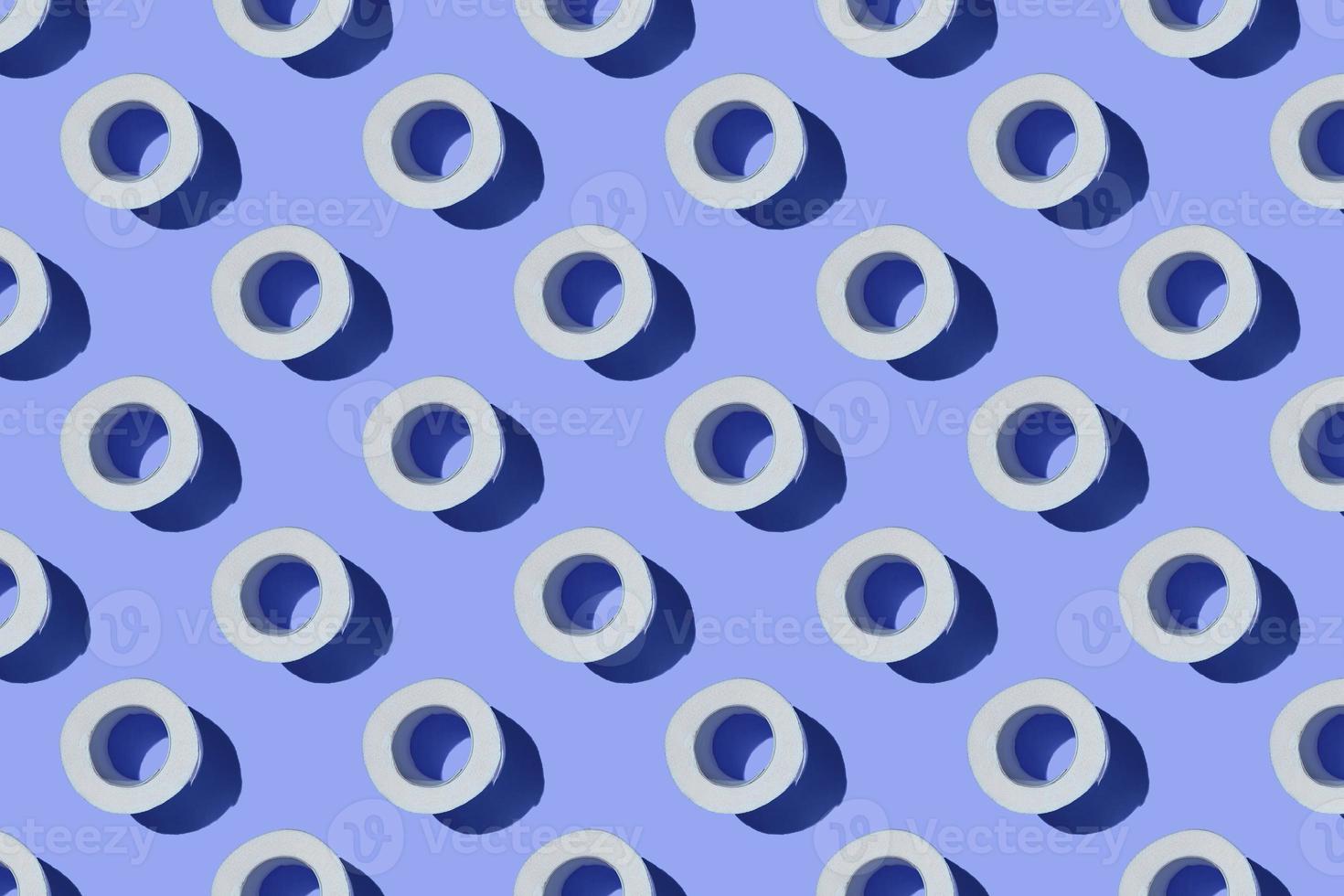 Seamless Pattern made of Toilet paper rolls isolated on blue background. The concept of hygiene. Pandemic panic concept. photo
