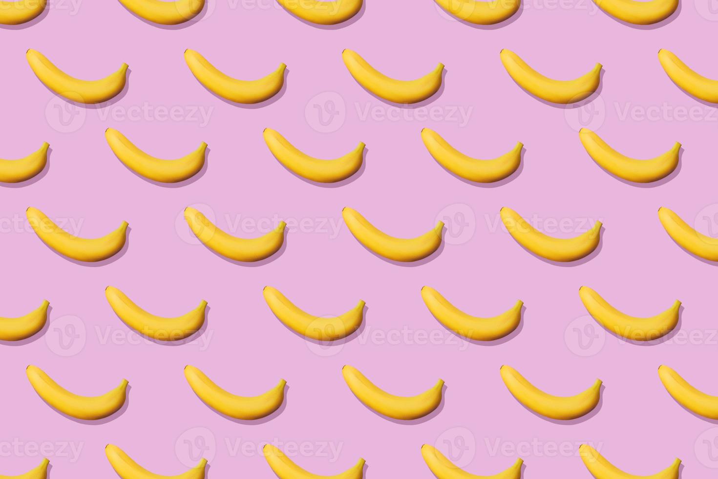 Colorful fruit pattern of fresh yellow bananas on pink background. From top view photo