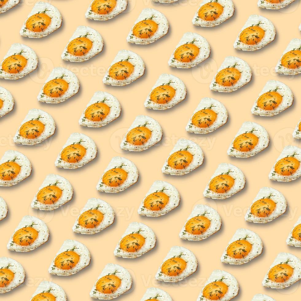 Chicken fried egg sprinkled with herbs isolated on light yellow background. Scrambled eggs close-up seamless pattern. photo