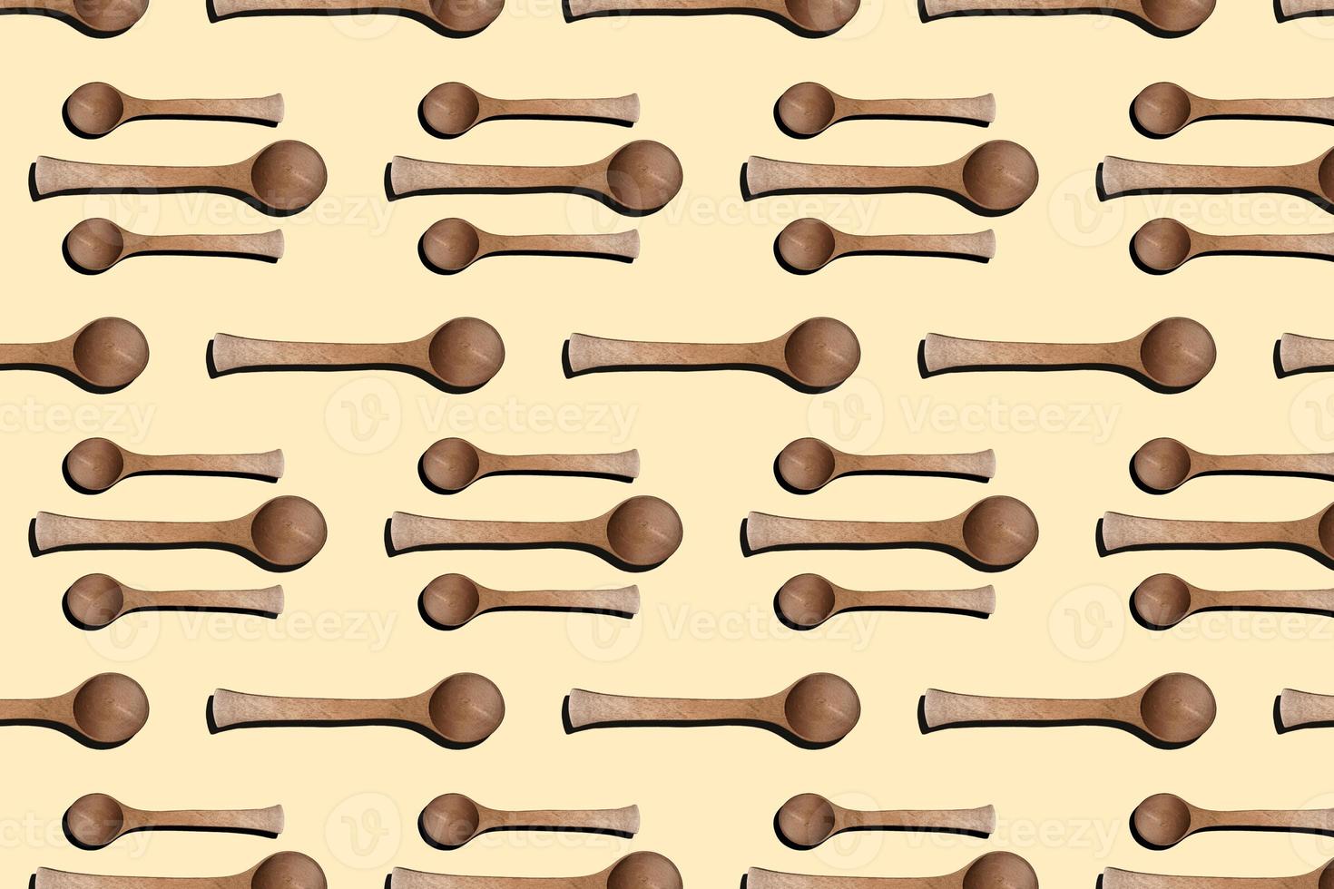 Wooden spoons, top view of wooden spoons isolated on yellow background. Kitchenware pattern background. photo