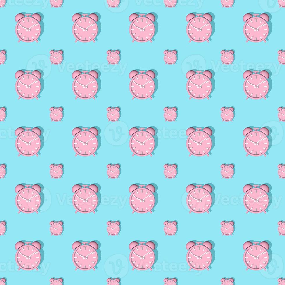 Pink alarm clocks big and small with shadow on blue background. Set. Seamless texture pattern. 3D illustration. photo