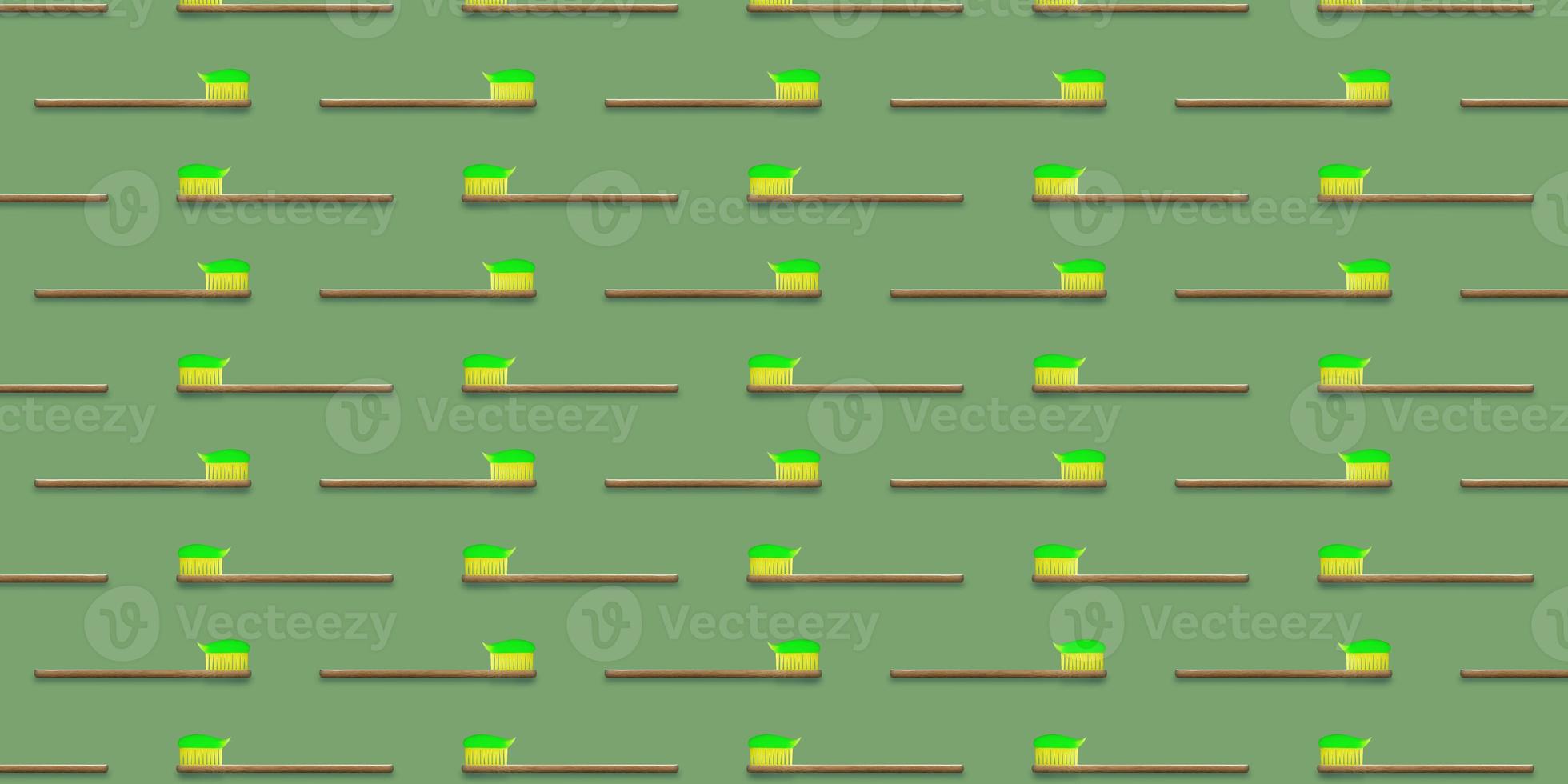Seamless pattern of wooden tooth brushes isolated on green background. Green toothpaste on toothbrush. photo