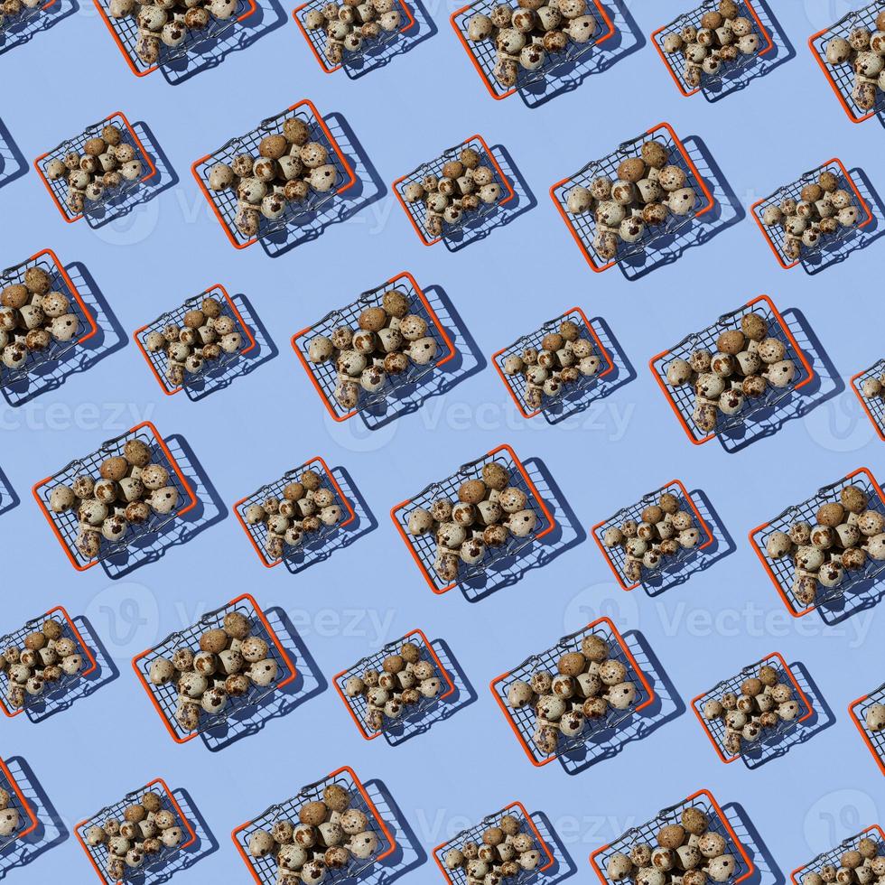 Seamless pattern of shopping baskets big and small with quail eggs on blue background. Top view. Website background. photo