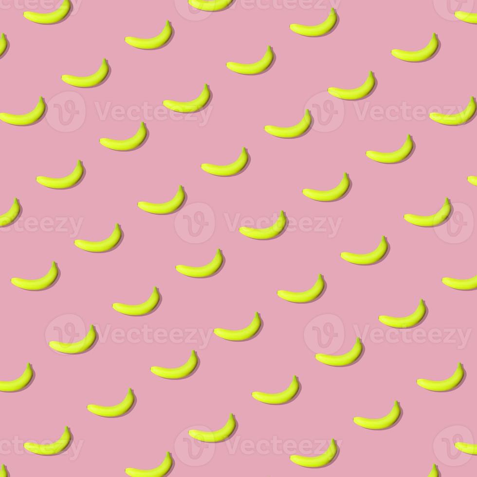 Colorful fruit pattern of fresh yellow bananas on pink background. From top view photo