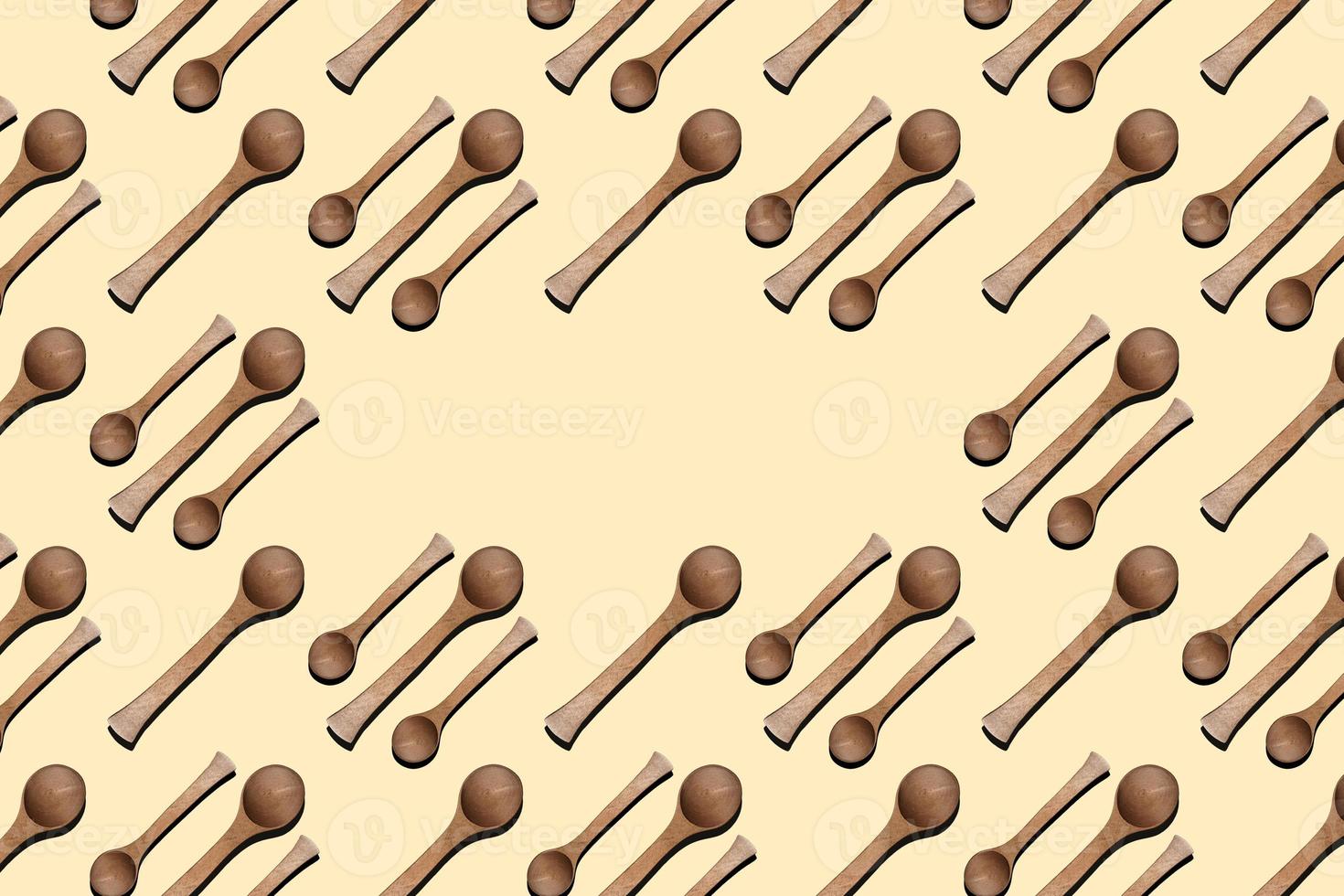 Wooden spoons, top view of wooden spoons isolated on yellow background. Kitchenware pattern with copy space. photo