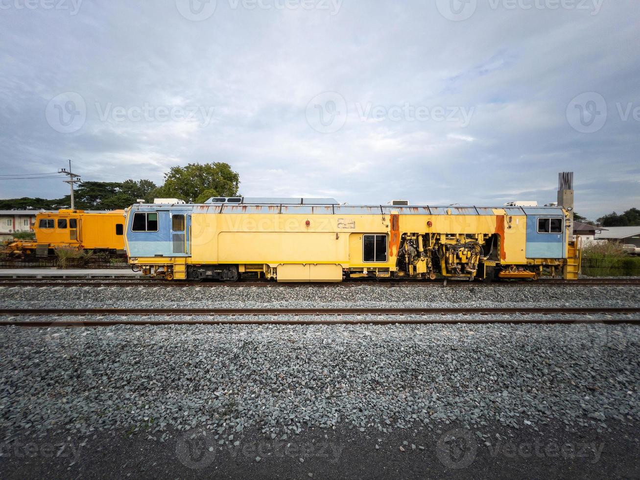 The ballast tamping machine is working to maintain the sleeper and ballast stone. photo