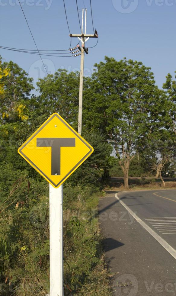 las señales de tráfico tengan cuidado con las carreteras y las intersecciones, conduzca despacio y tenga cuidado con las muchas intersecciones que se encuentran más adelante en la carretera rural y el hermoso cielo azul-blanco por la noche. foto