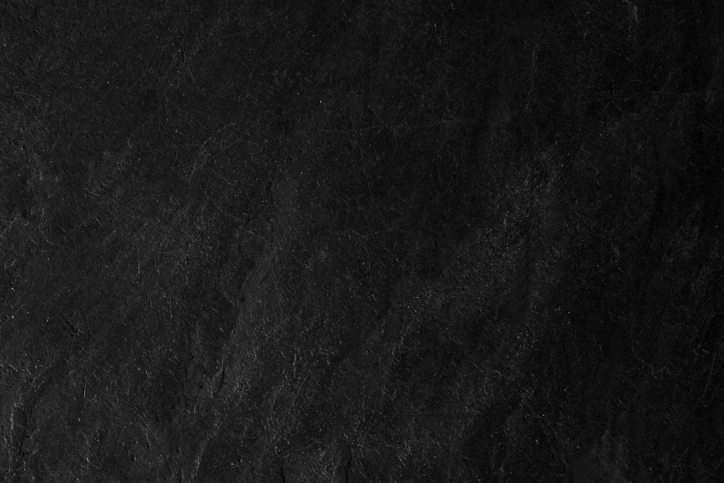 superficie de la textura de piedra negra áspera, tono gris-negro. use esto para fondo de pantalla o imagen de fondo. hay un espacio en blanco para el texto foto