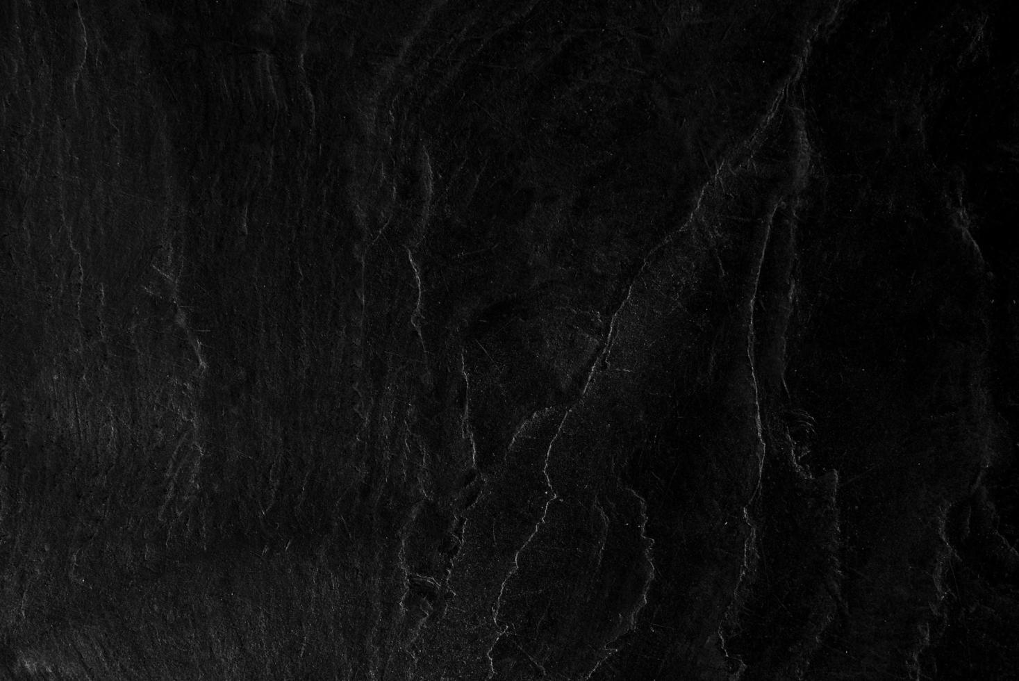 superficie de la textura de piedra negra áspera, tono gris-negro. use esto para fondo de pantalla o imagen de fondo. hay un espacio en blanco para el texto foto