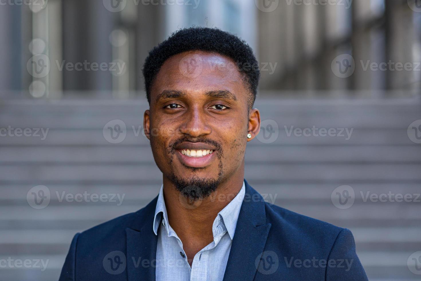 close up portrait happy African American business man looking at camera outside. photo