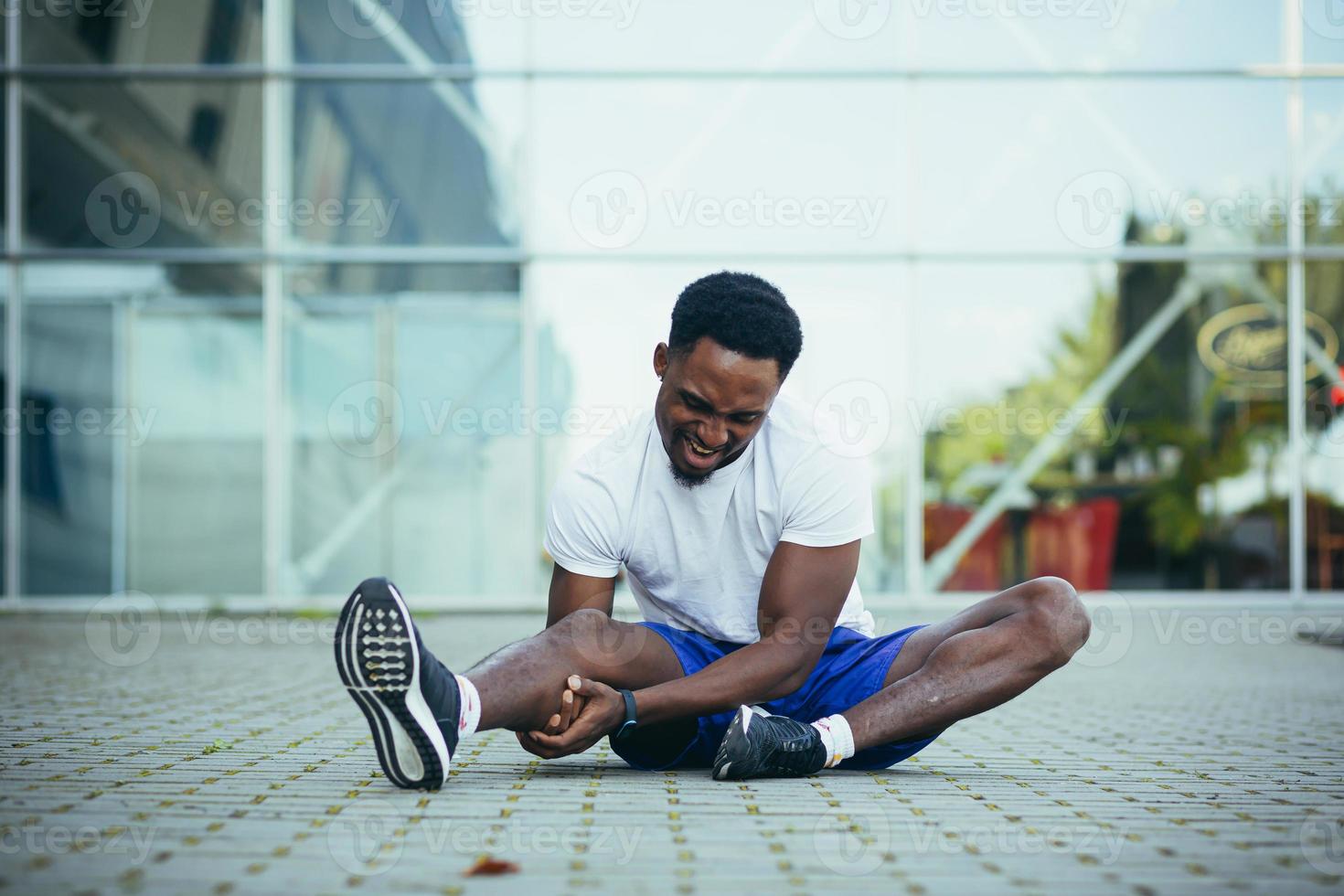 un hombre cansado después de correr masajea su pierna, tiene dolor severo en las rodillas y los músculos foto