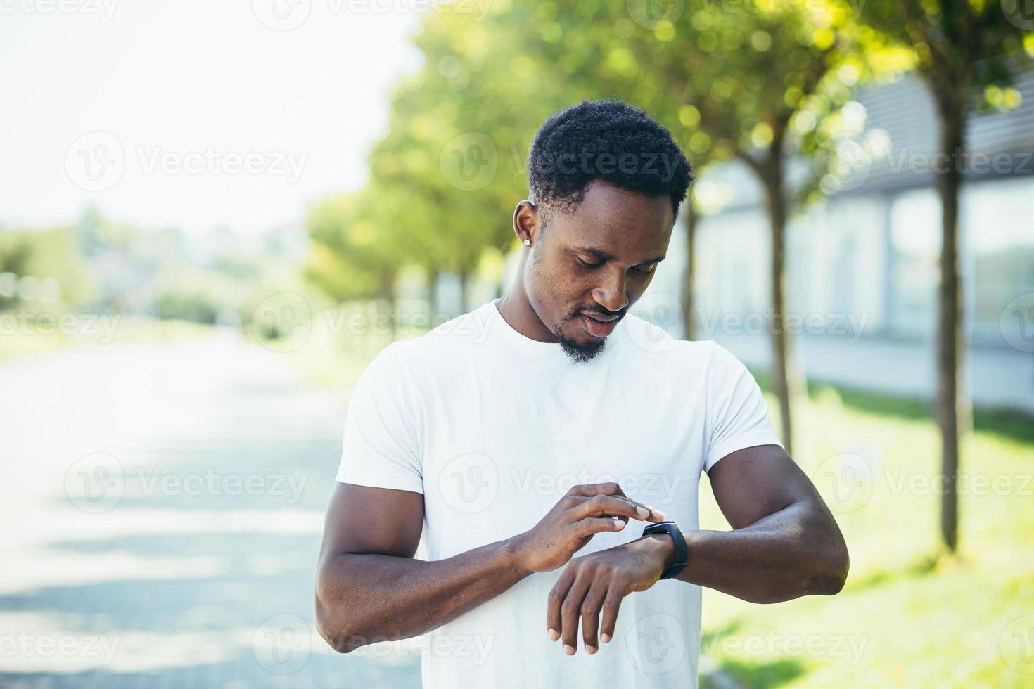 joven afroamericano, en un trote matutino con una camiseta blanca en el parque, cambia foto